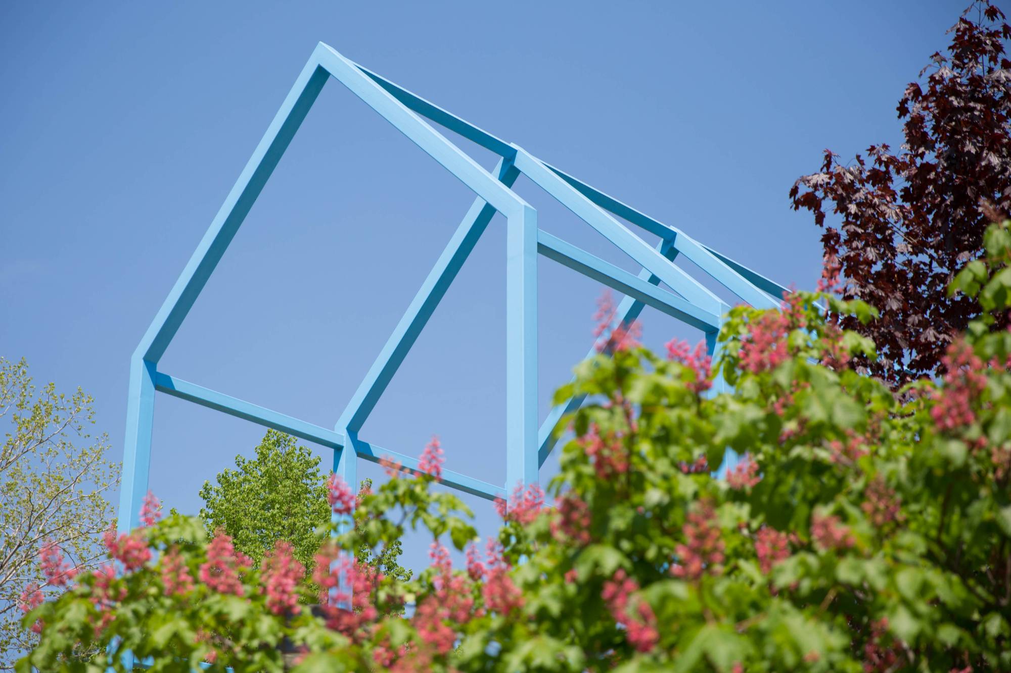 Blue sculpture with greenery in foreground